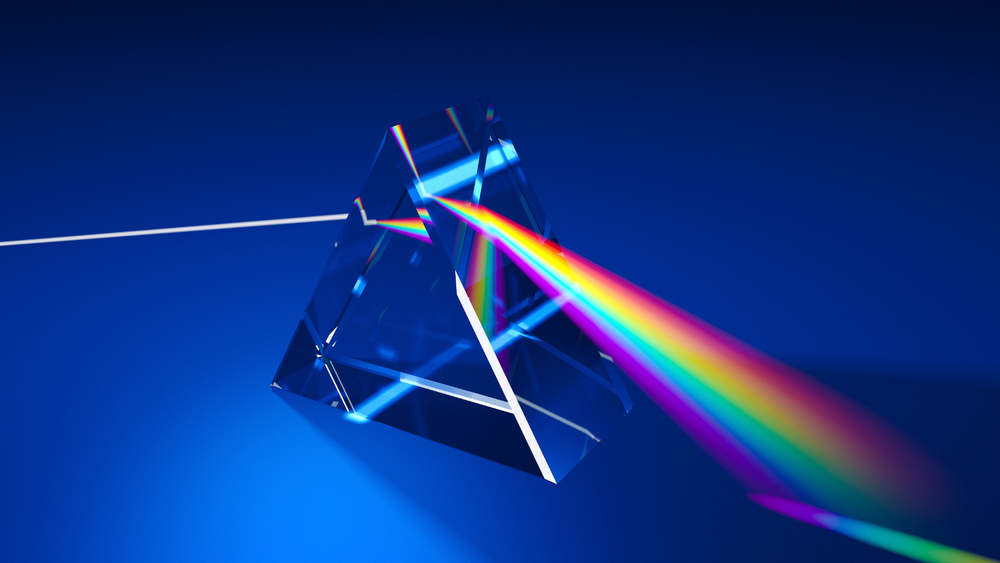 image of a triangular prism refracting white light into a rainbow, on a blue background