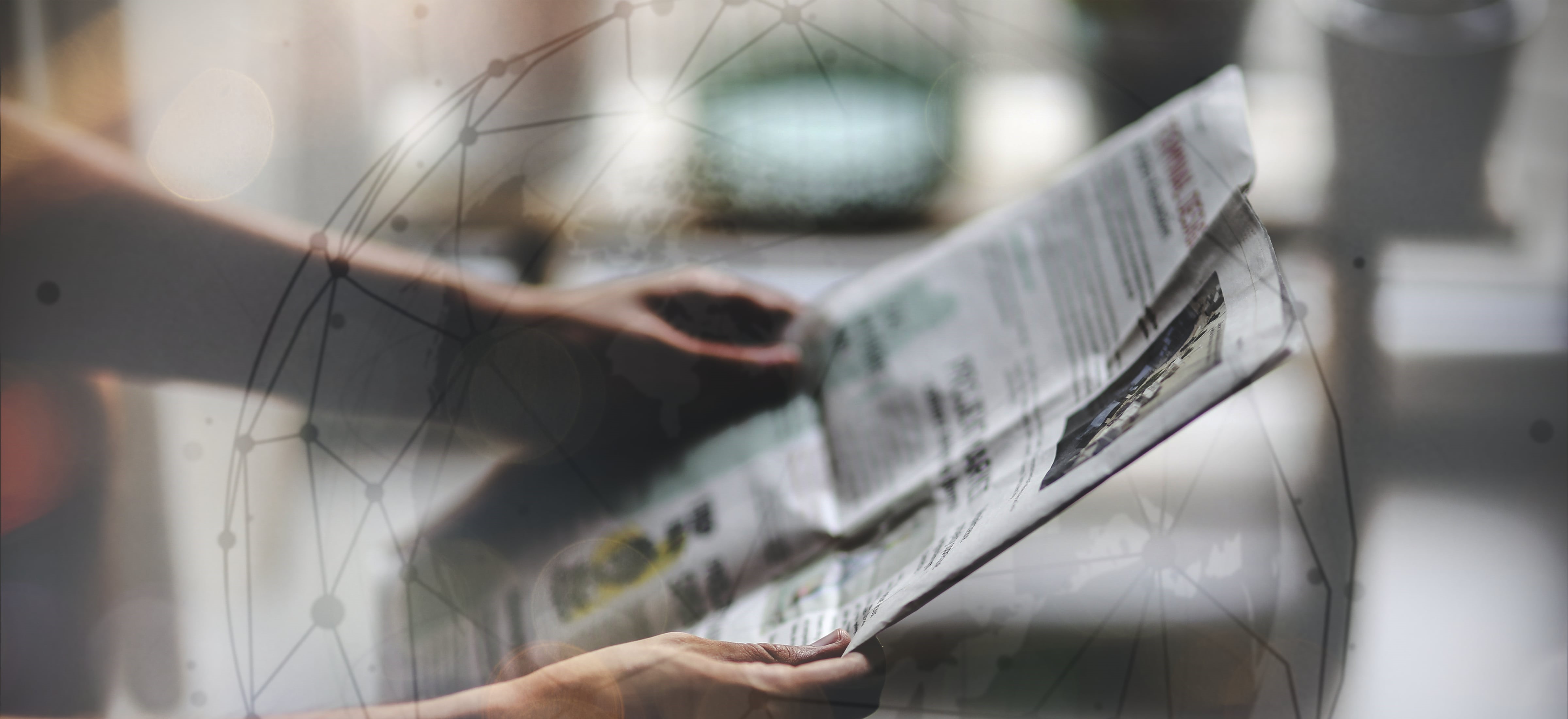 Two hands holding a newspaper