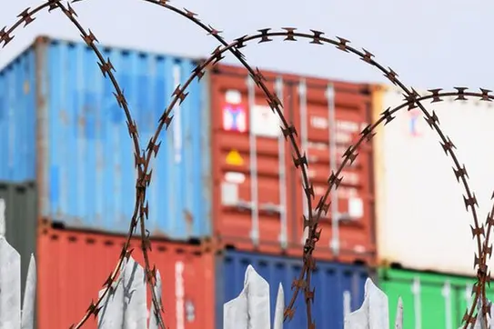 Barbed wire in front of shipping containers