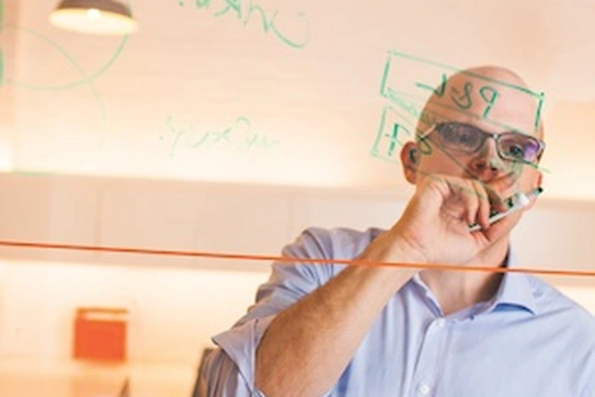 Image of man writing on glass with marker
