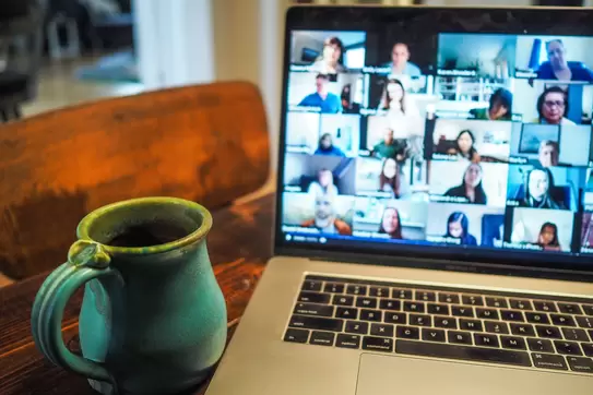 an open laptop computer shows a remote meeting in progress