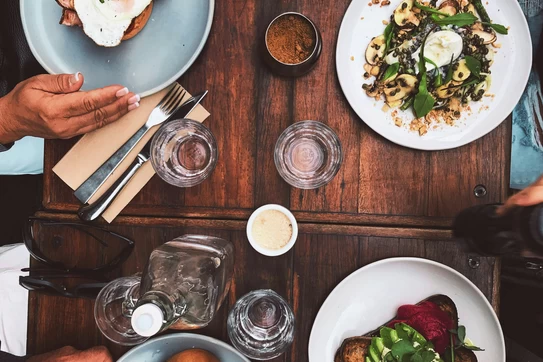 a thanksgiving table with food and people's hands