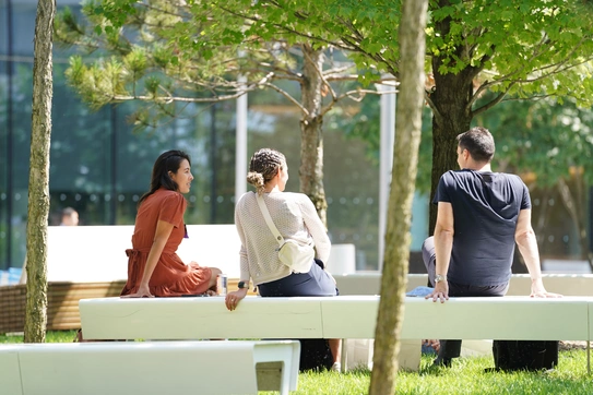 students on a bench outside columbia business school 